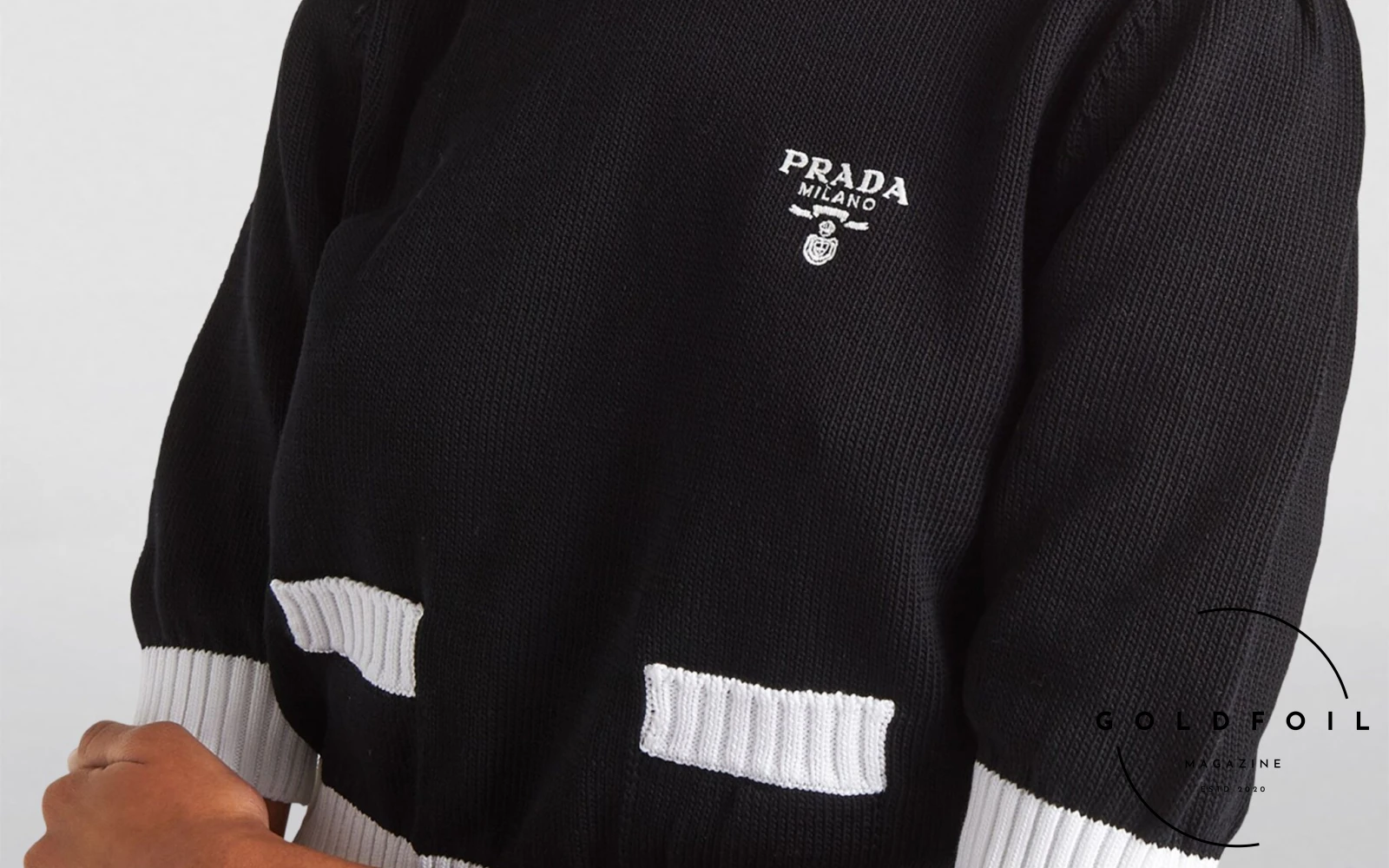 For a more minimal look, the model is wearing a Prada contrast trim sweater perfect for the Christmas season in the warmer climates 2023 For a more minimal look, the model is wearing a Prada contrast trim sweater perfect for the Christmas season in the warmer climates 2023